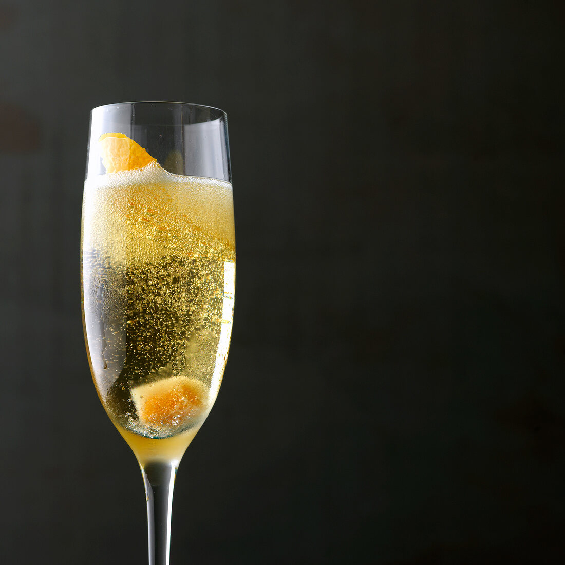 Spiked champagne cocktail with orange peel