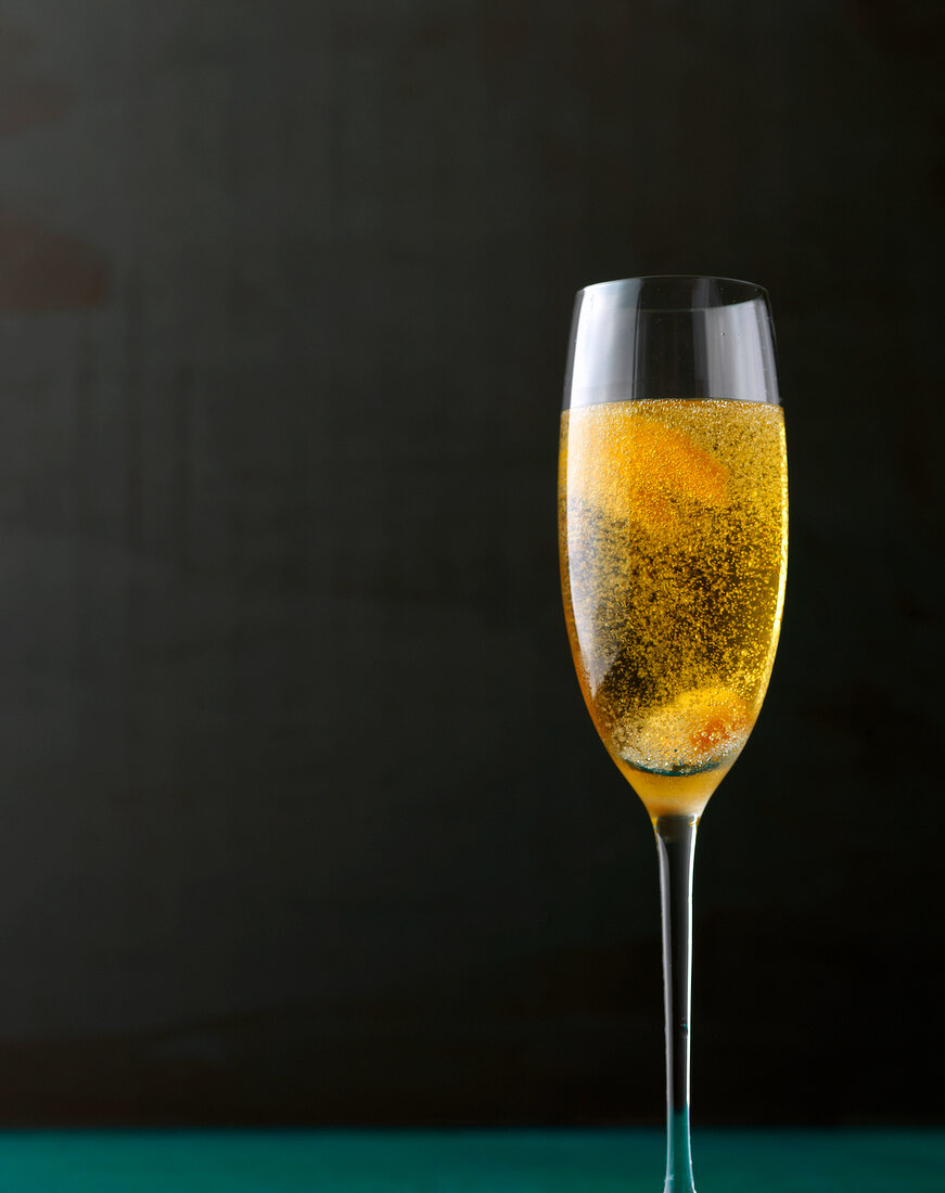 Orange spiked champagne cocktail with orange tingles