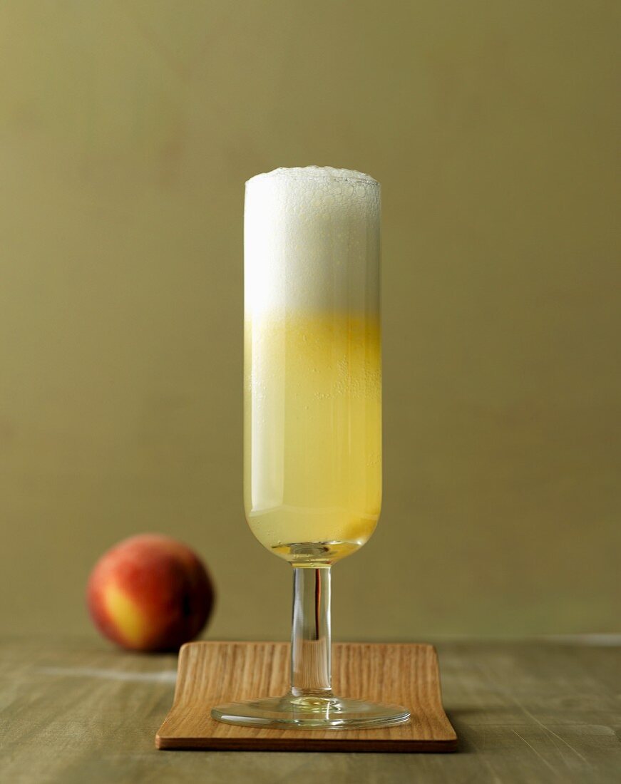 A classic bellini: cocktail with Prosecco and peaches in a champagne glass