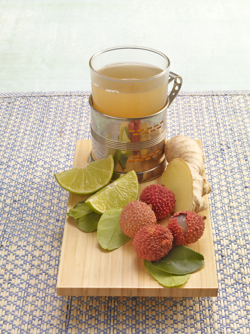 Asian lychee tea with ginger, lime and lychee on wooden tray