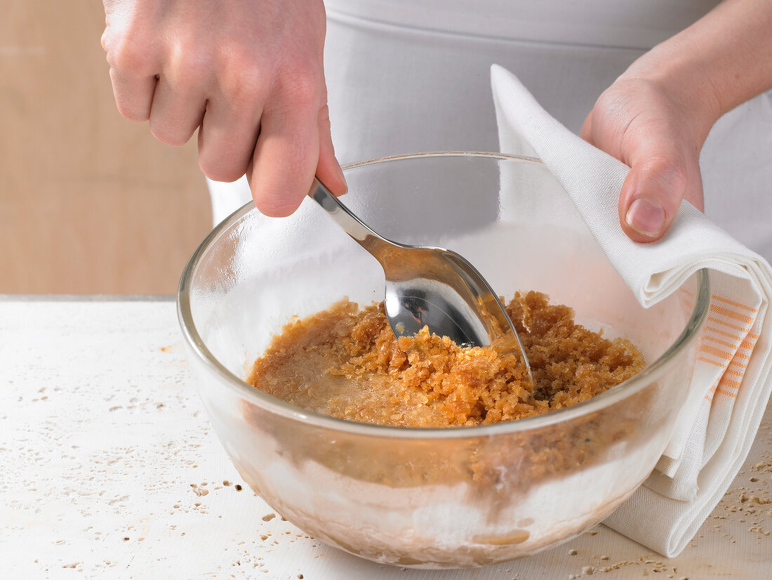 Scooping mixture from glass bowl with spoon, step 2