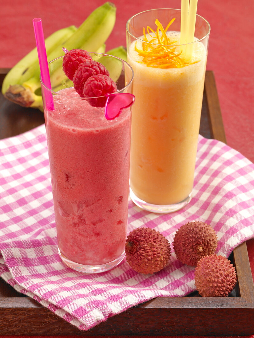 Pink batida raspberry and mandarin coladas with lychees on serving tray 