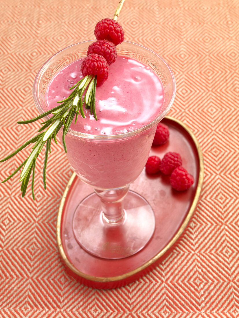 Raspberry smoothie in glass with raspberries