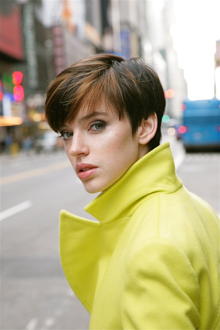 Portrait of woman with short hair wearing jacket, looking over shoulder