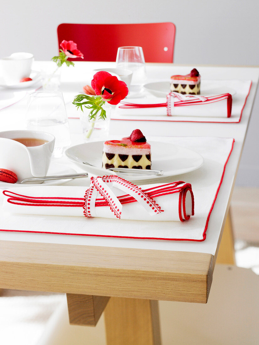 Laid table with red and white linen and tableware
