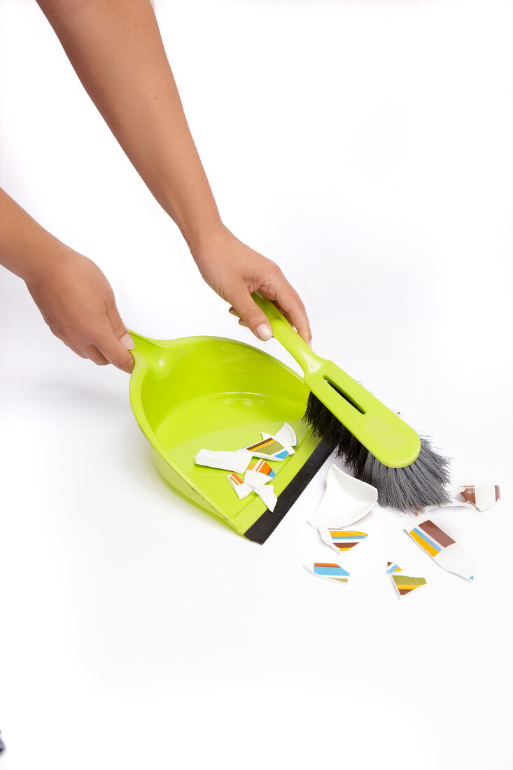 Sweeping fragments with broom on white background