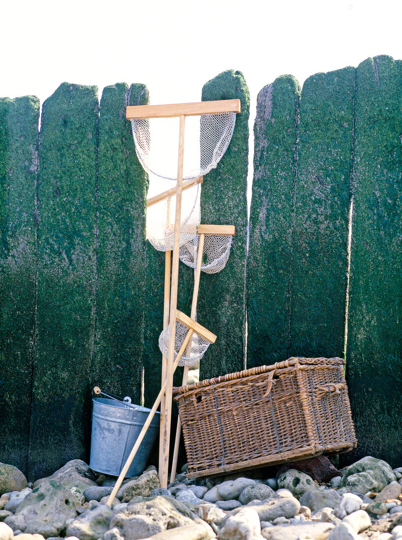 Fishing basket, bucket and fishing nets against pier