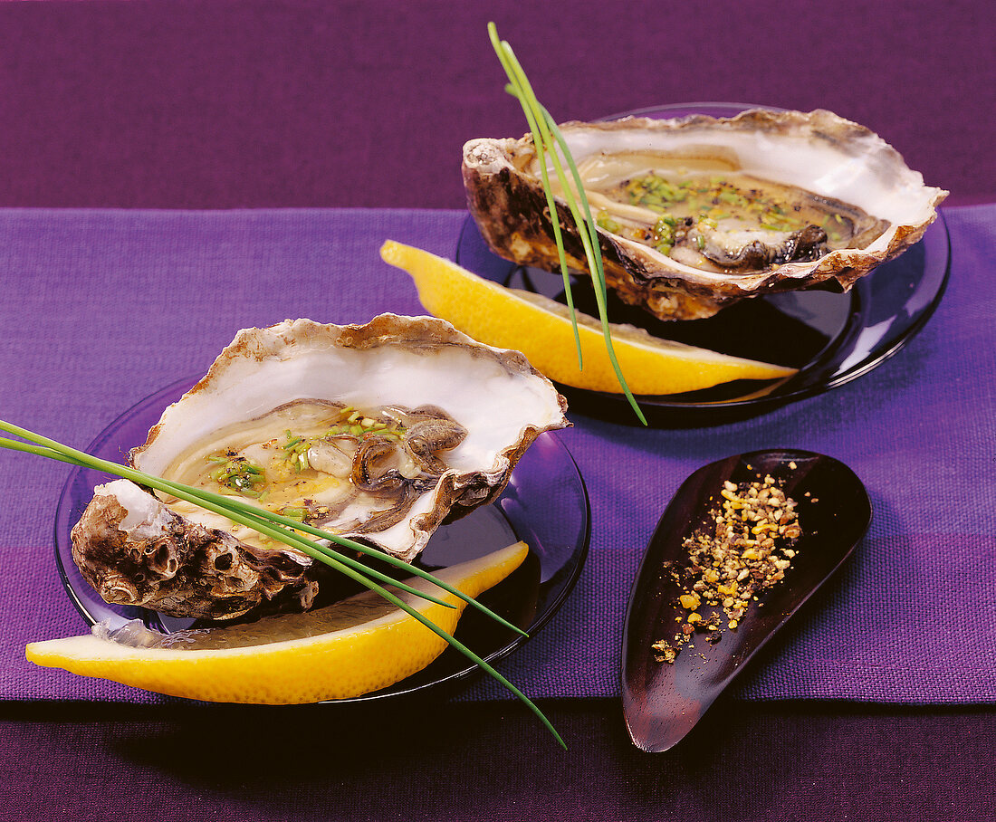 Oyster with lemon pepper and chives on plate