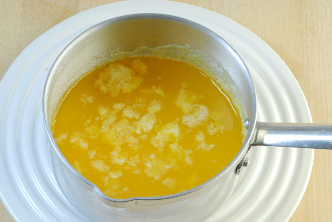 Cooled melted butter in sauce pan while preparing hollandaise sauce, step 1