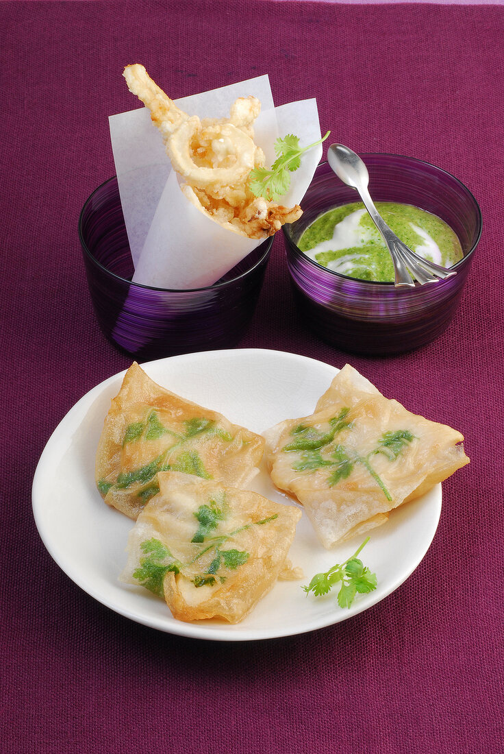 Fried squid in paper packets with pangasius and pesto