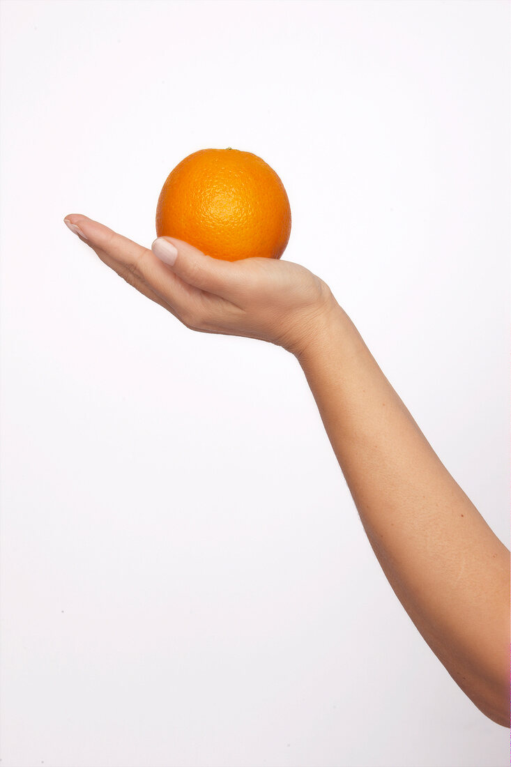 Orange on hand against white background