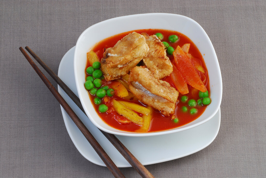 Fried snapper with sweet and sour peas stew in bowl