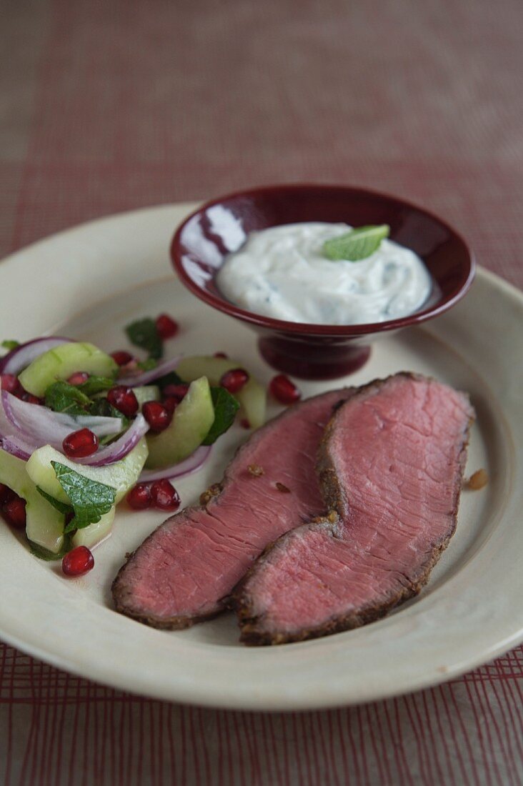 Roast beef with a cucumber and pomegranate salad and a yoghurt dip