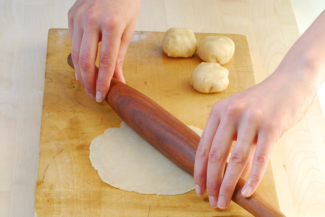 Dough being rolled into small circles while preparing samosas, step 3