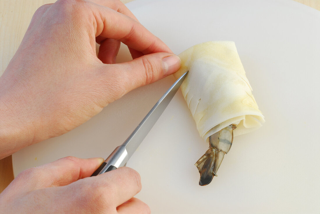Edges of dough being cut in diamond shape while preparing crunchy prawns, step 3
