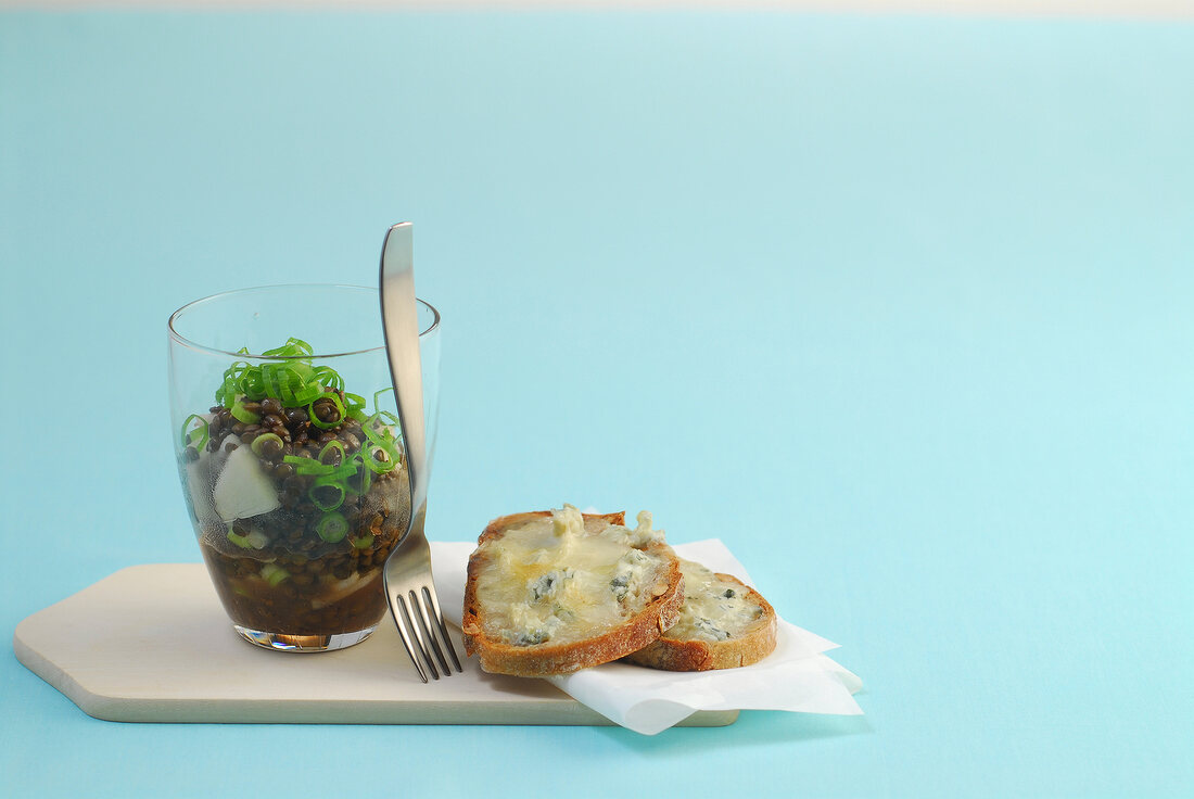 Lentil salad with Gorgonzola-crostini on blue background