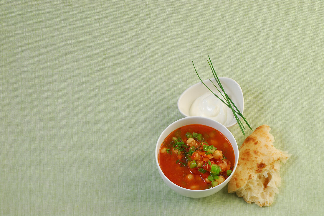 Tomato soup with chickpeas in bowl, overhead view