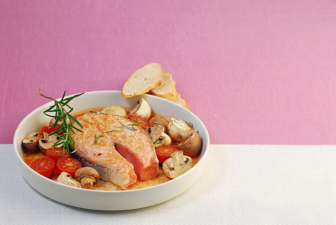 Salmon cutlets with tomatoes and mushrooms in serving dish