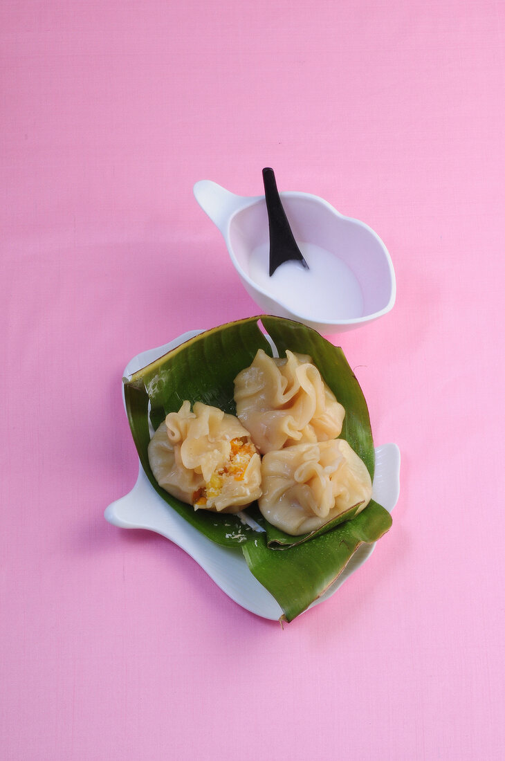 Wok, Süße Wantans auf einem Bananenblatt mit Kokosdip