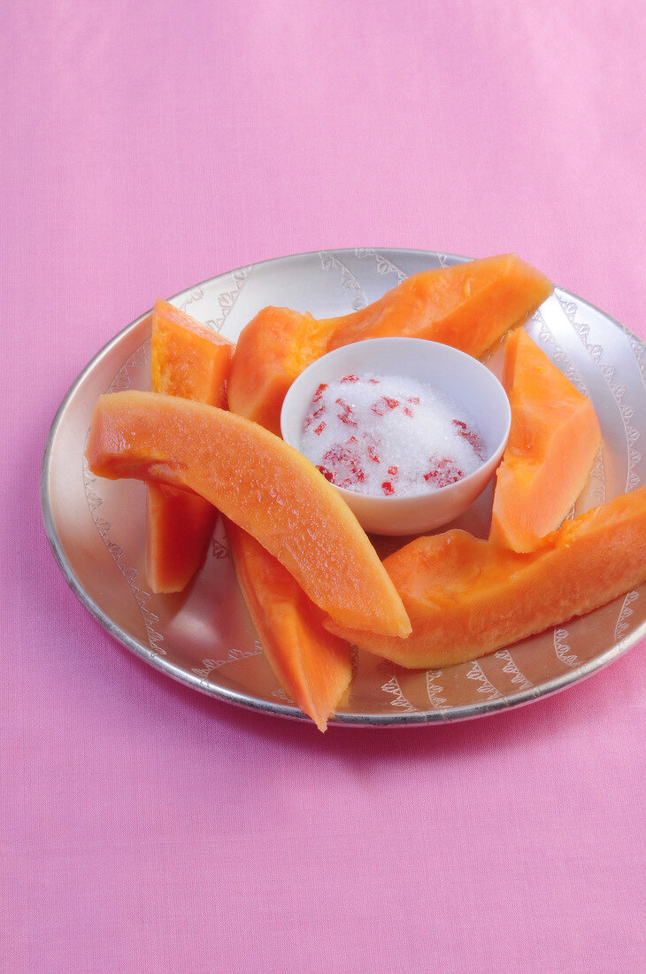 Close-up of papayas pieces with chili sugar on plate