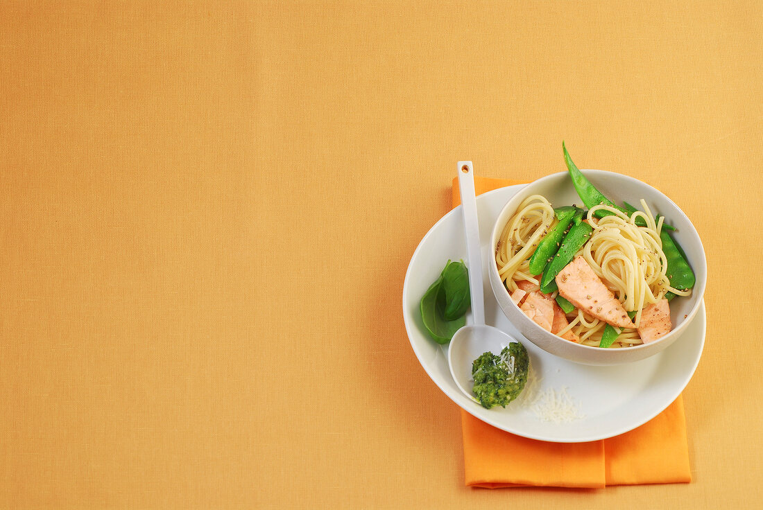 Bowl of salmon spaghetti and pesto sauce on spoon