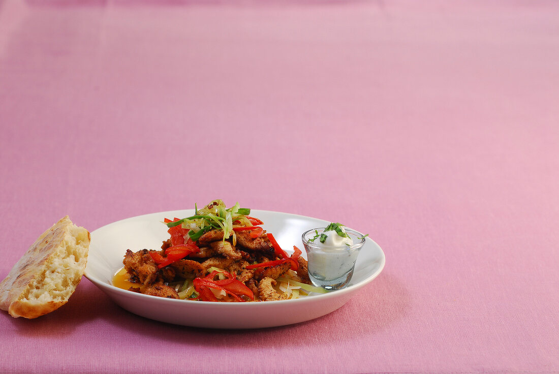 Turkey gyros with yogurt sauce on pink background