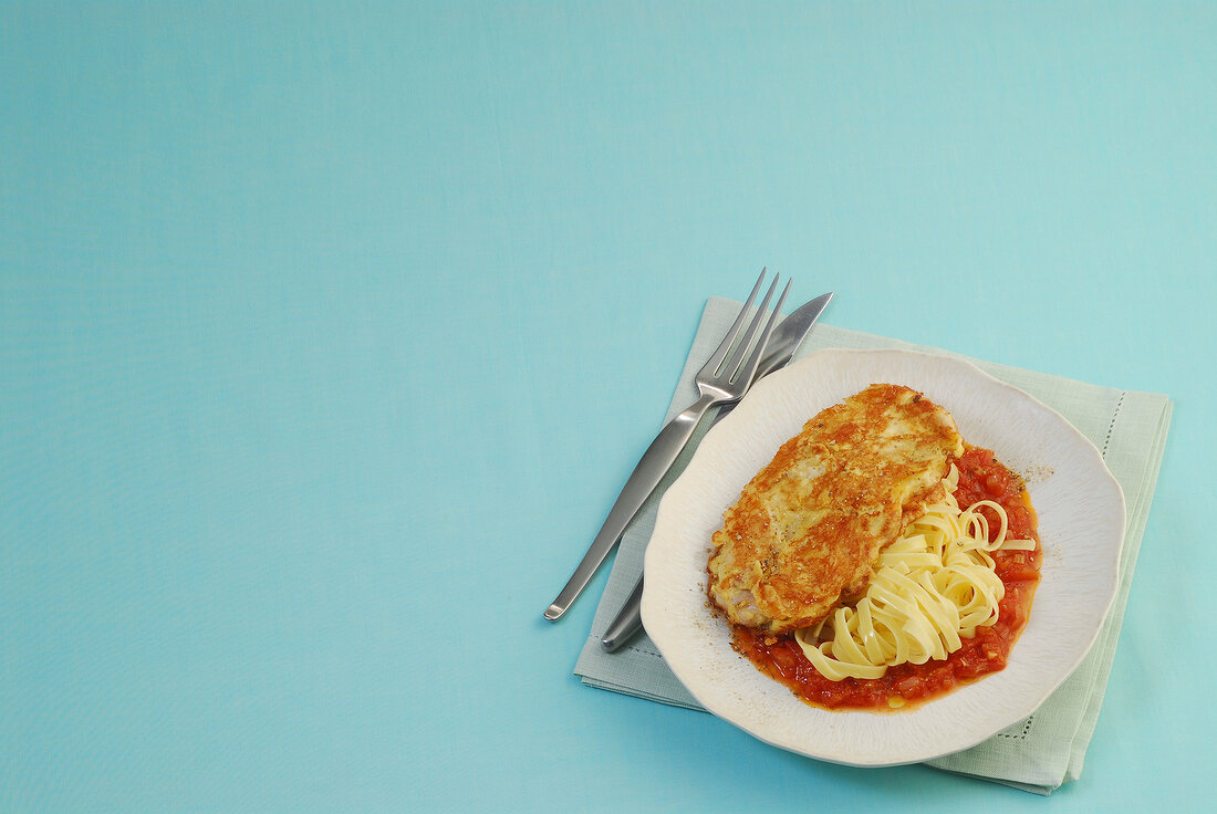 Turkey piccata with tomato sauce on plate