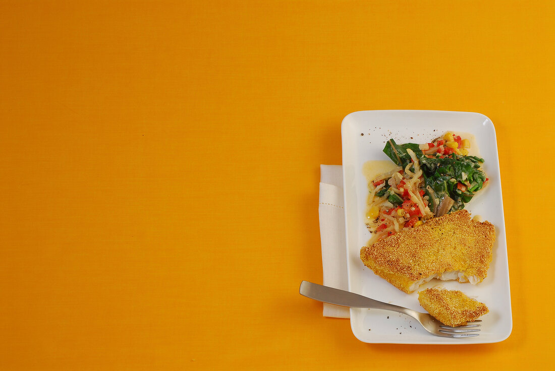 Fish with polenta crust and chard on plate