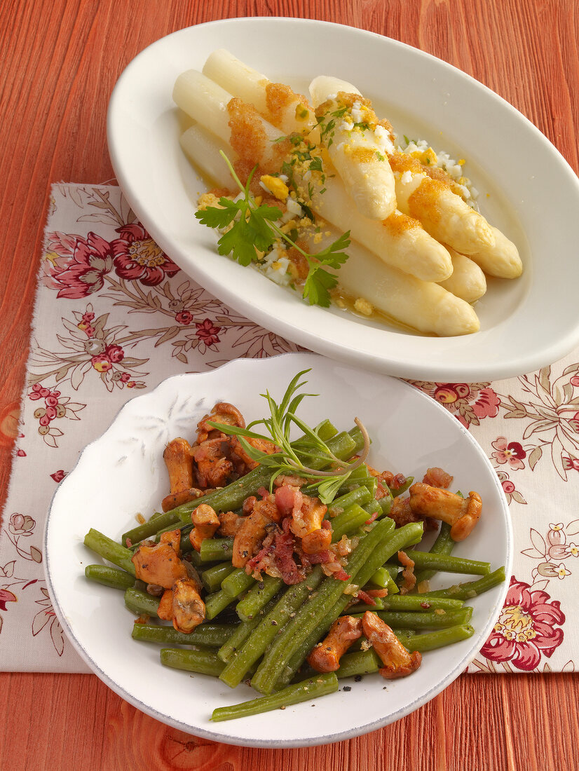 Asparagus with green beans and chanterelles on serving plates