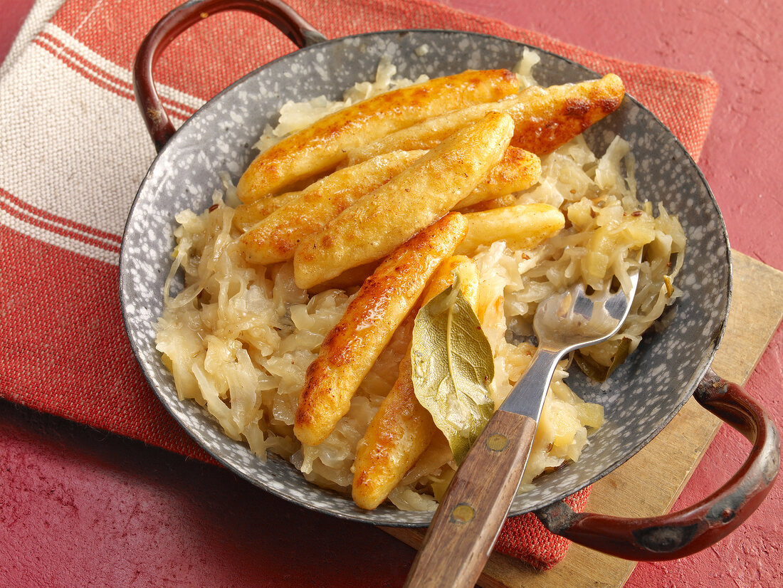 Potato dumplings with sauerkraut and bay leaf in wok