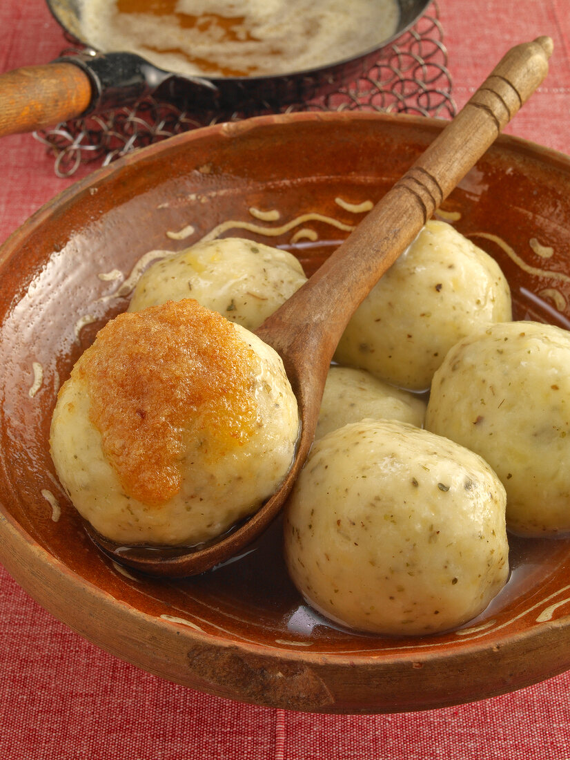 Potato dumplings with brown butter in serving dish