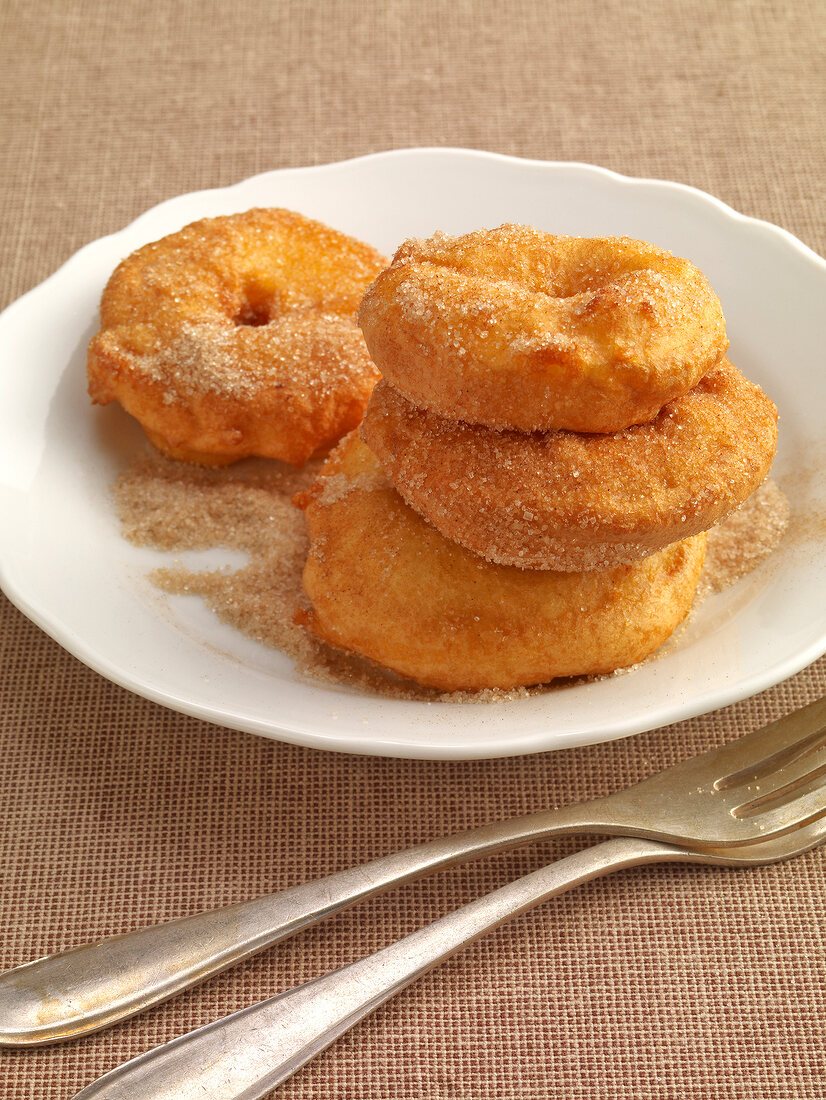 Apple rings fried in batter with sugar on plate