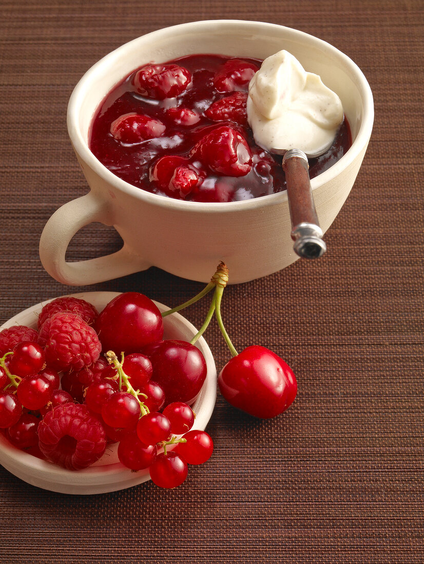 Red berry compote with vanilla cream, cherries and raspberries in cup