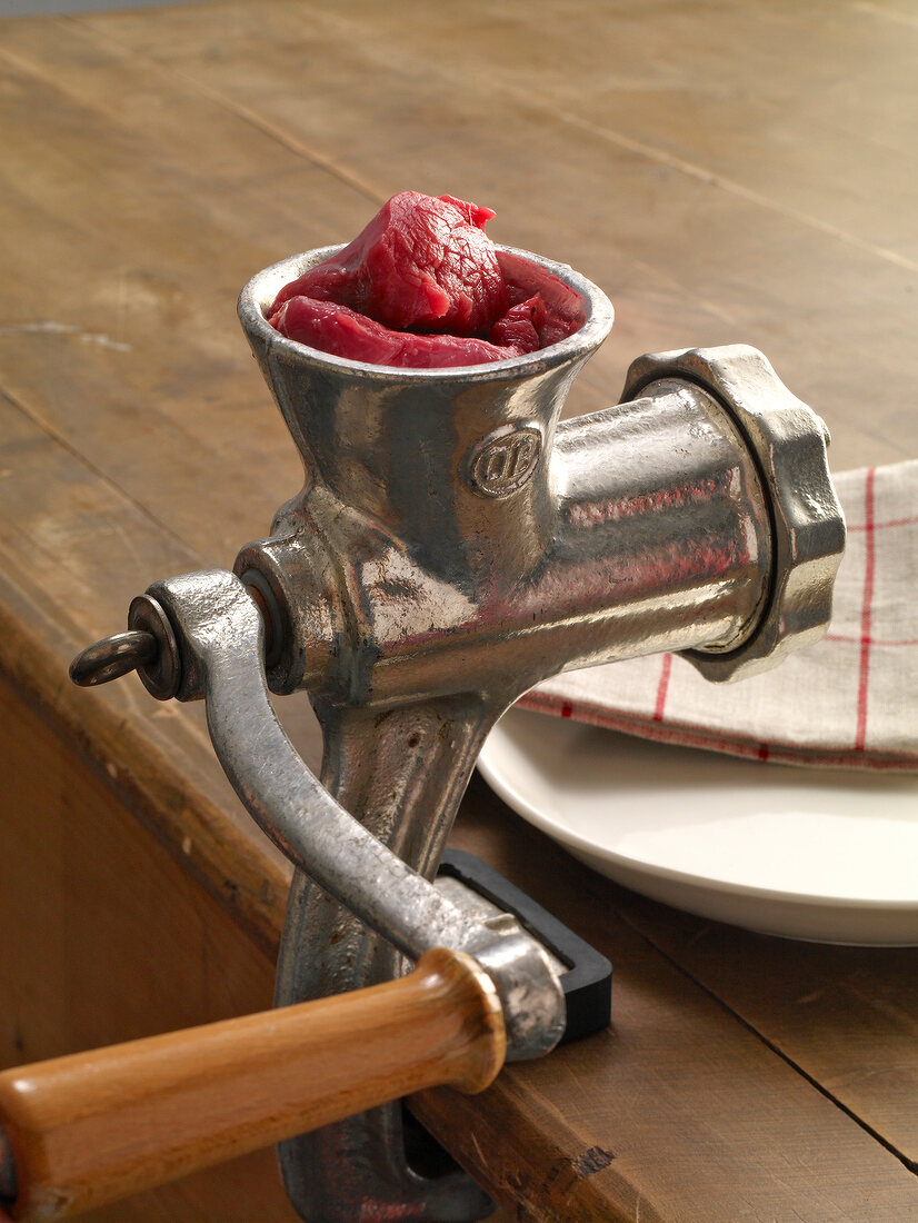 Raw meat in meat grinder