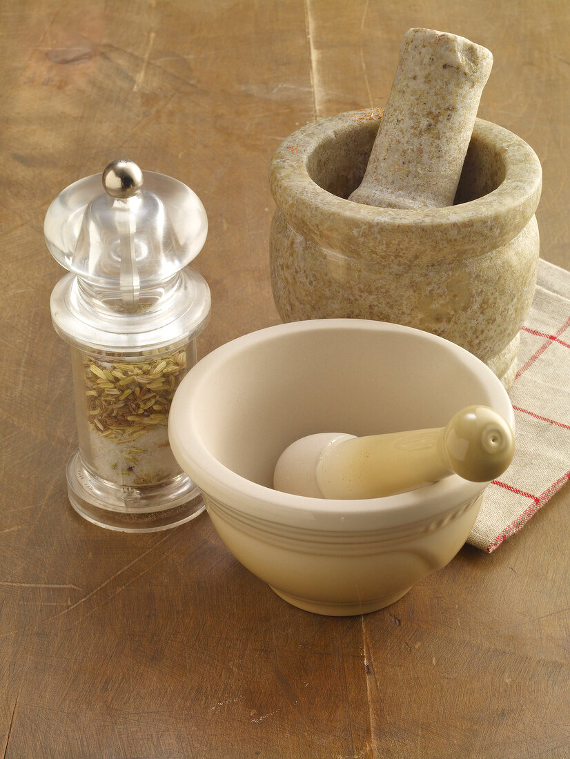 Two mortar and pestle with spice mill on table