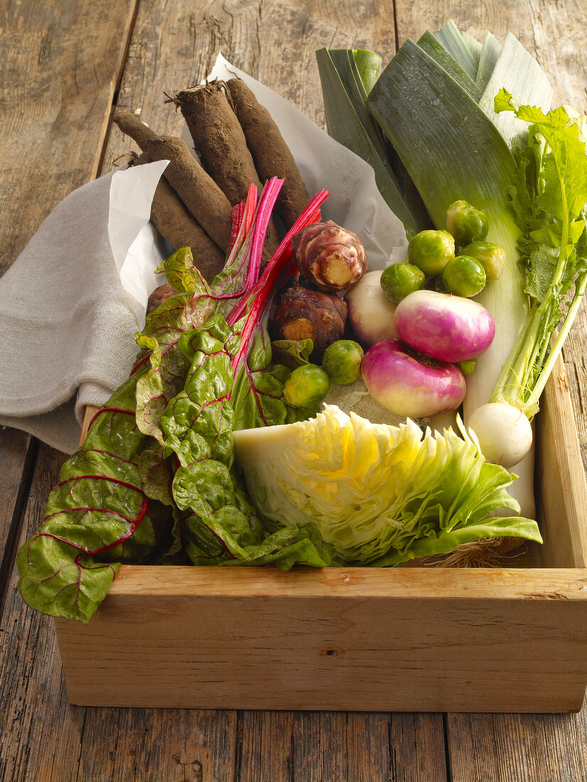 Cabbage, leek, beet chard, Brussels sprouts and Jerusalem artichokes in wooden box