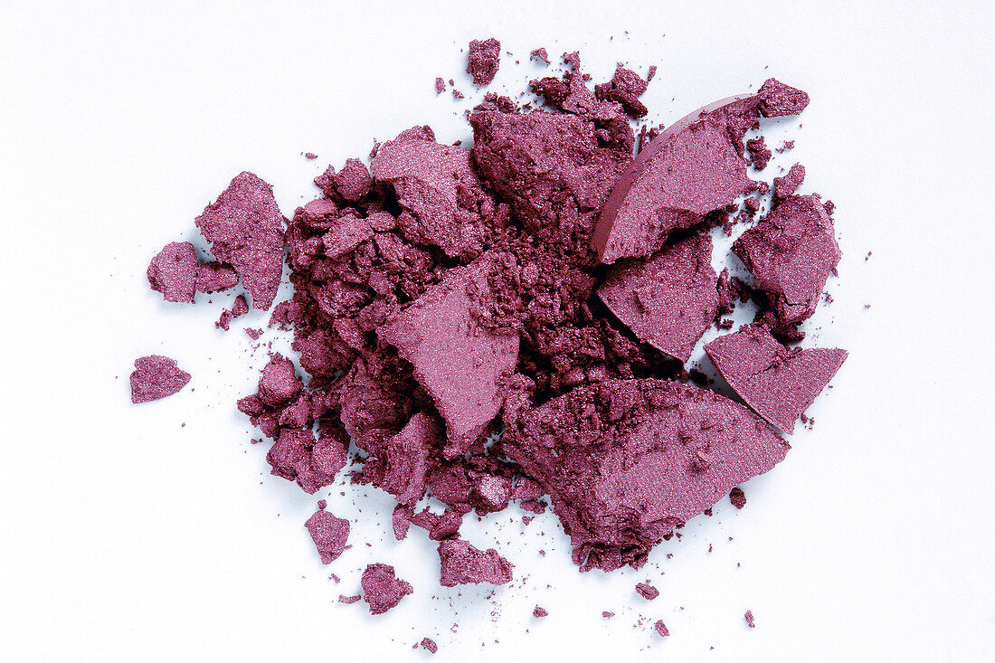Close-up of loose purple eye shadow on white background