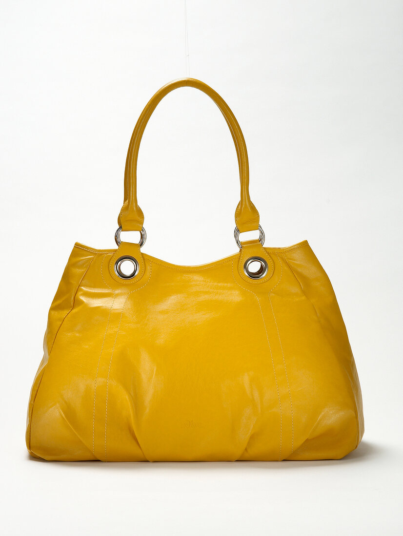 Close-up of yellow leather handbag on white background