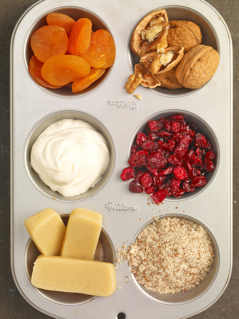 Apricots, marzipan, walnuts and hazelnuts in cupcake mould, muffin ingredients