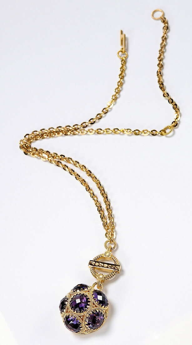 Gold plated chain with purple stones pendant on white background