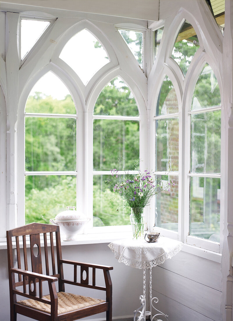 Table and chair in front of white colonial window at Rieseby, Germany