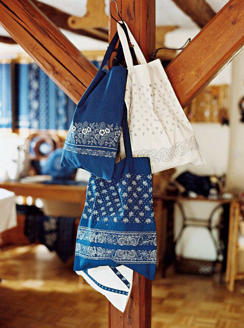 Blue and white cloth bags with print hanging on bar