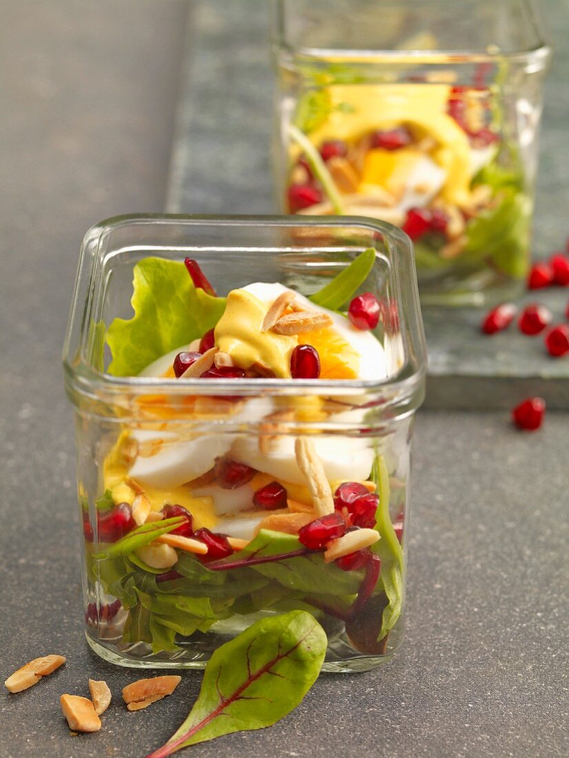 Egg salad at with pomegranate seeds served in jars on beds of lettuce