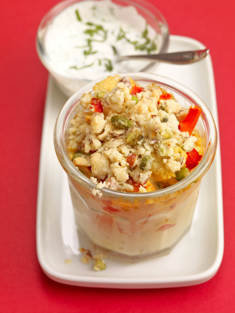 Yoghurt sauce with Vegetable curry crumble in glass kept on tray