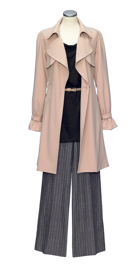 Trench coat over linen top and pinstriped pants on mannequin against white background