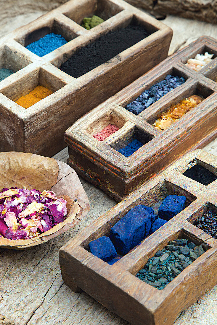 Colourful powders and pigments in wooden boxes