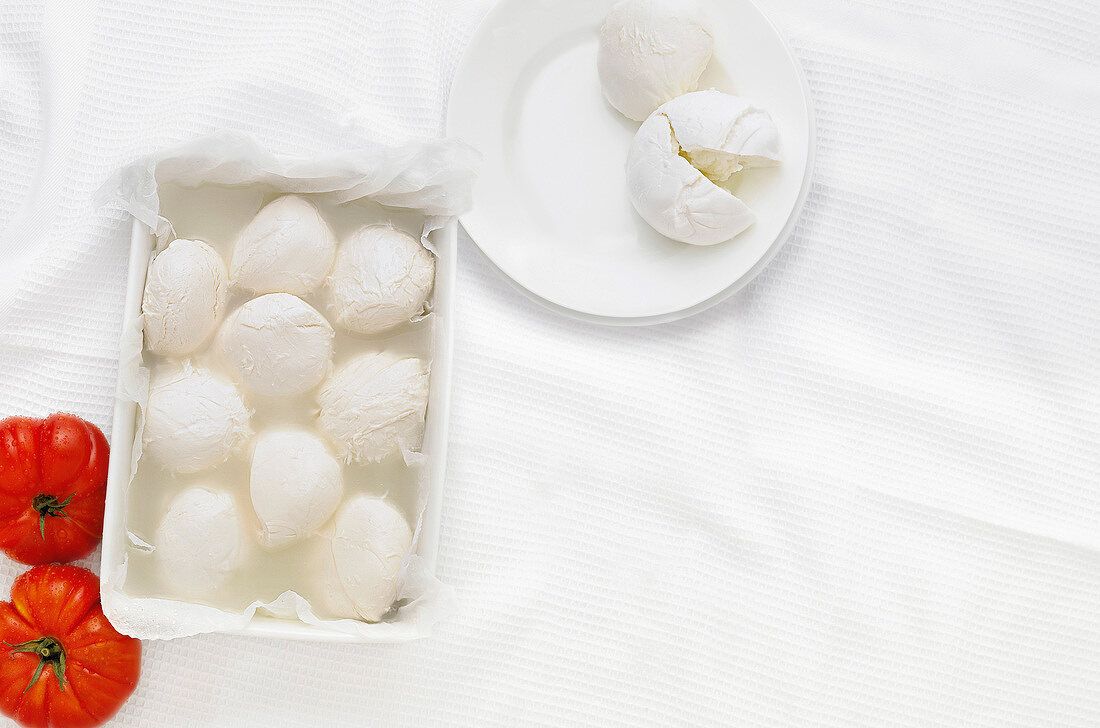 Mozzarella balls with tomatoes on white background