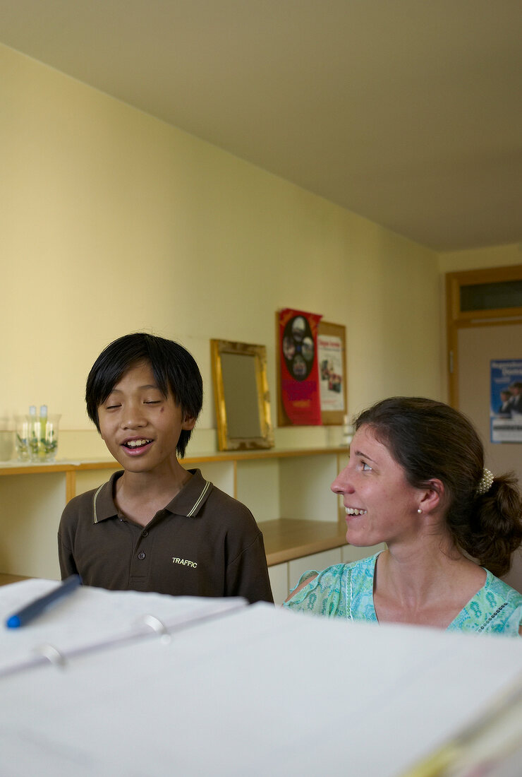 Young boy singing with his teacher