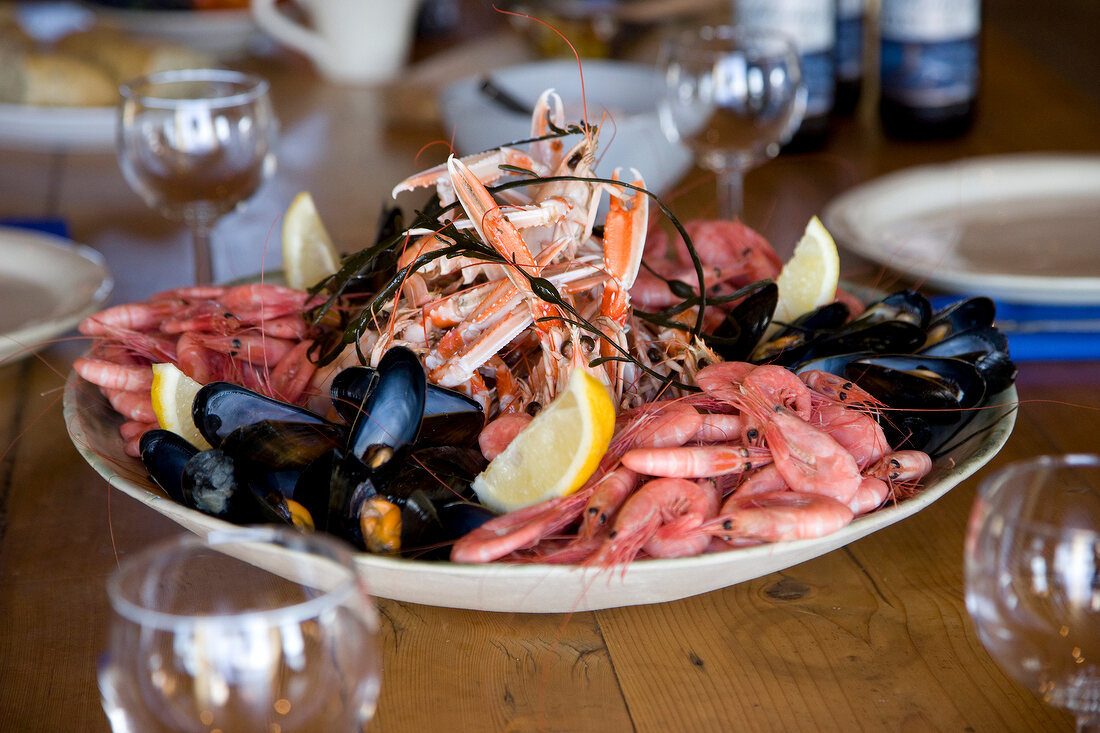 Shrimp, mussels, lobster and lemon wedges on plate