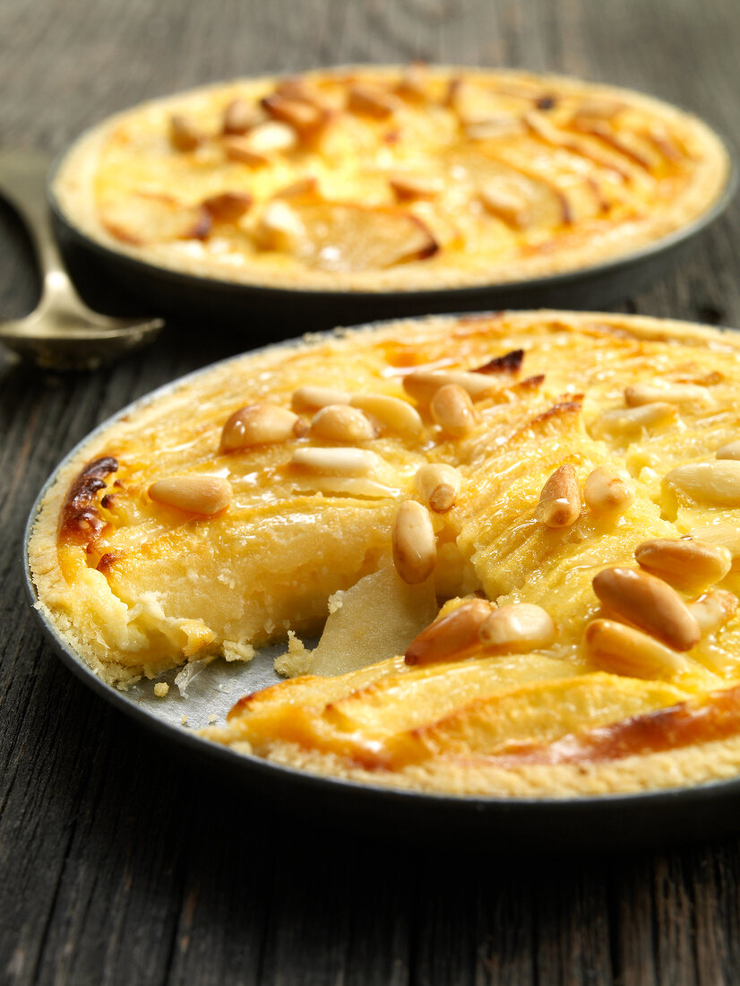 Apple tart with cream cheese and pine nuts on tray